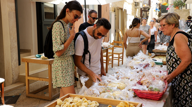 tourists buying pasta in italy