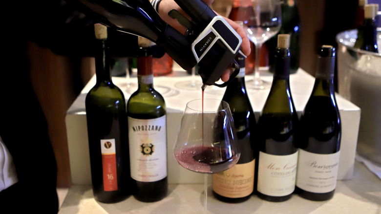 Hand pouring wine using a Coravin