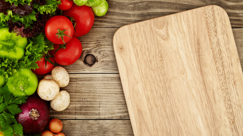 Wooden cutting board and vegetables