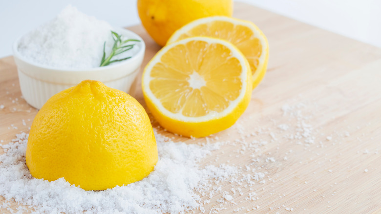 Halved lemons and sea salt on a cutting board