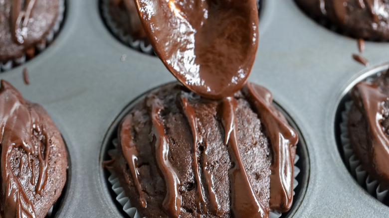 ganache being drizzled onto muffins