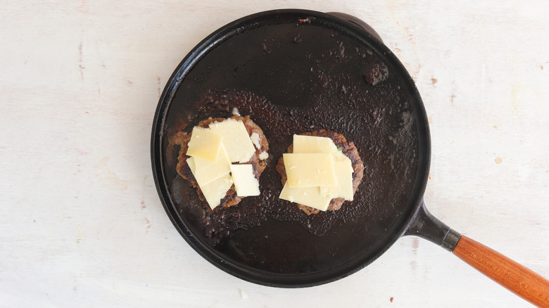 cheese on patties in skillet