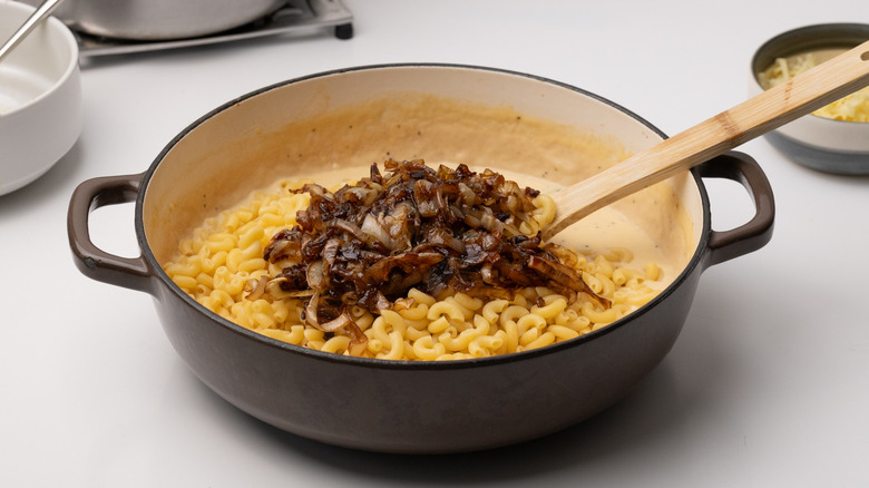 combining macaroni with sauce