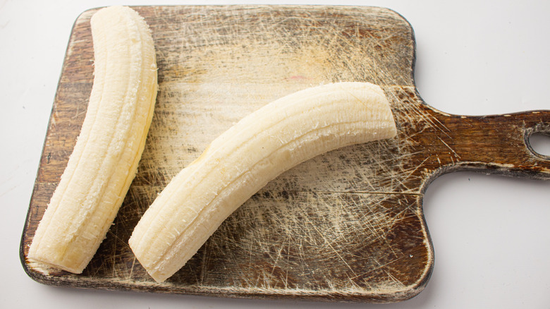 peeled bananas on cutting board