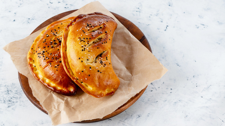 two pasties in wood bowl