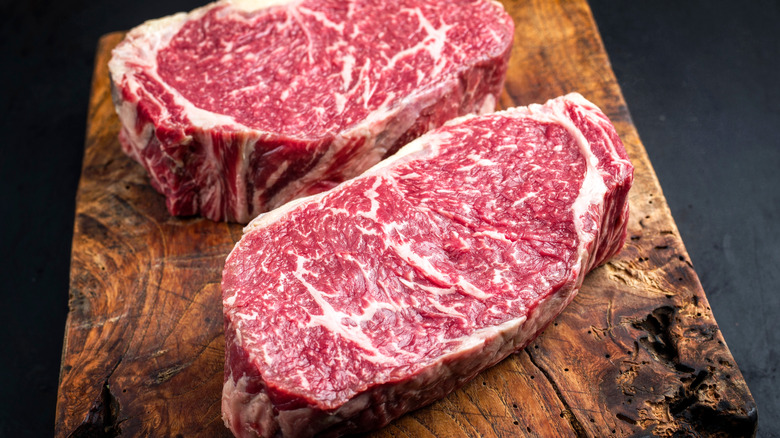 two thick steaks served on cutting board