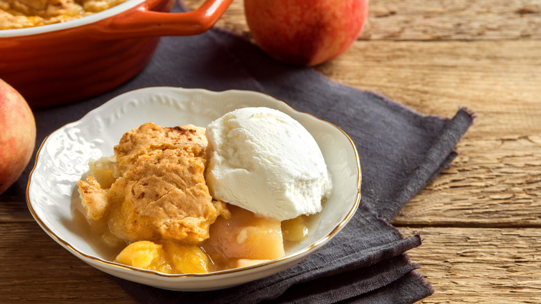 Peach cobbler in a bowl with ice cream