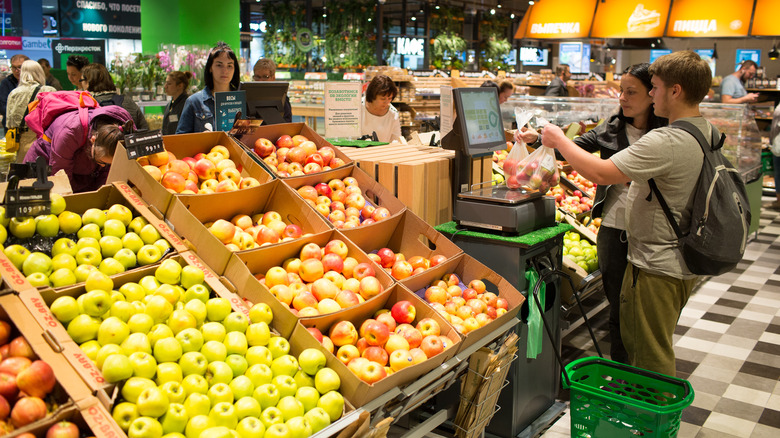 Customers weighing produce in supermarket