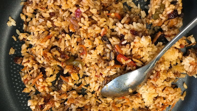 Dirty rice in skillet with spoon