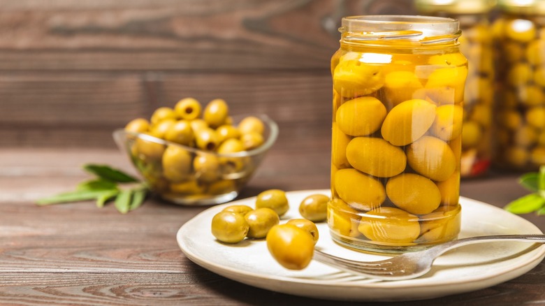 Jar of green olives on a plate