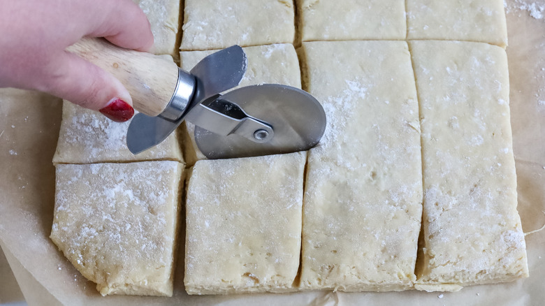 Beignet dough being cut into squares