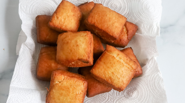 Cooked beignets on a paper plate