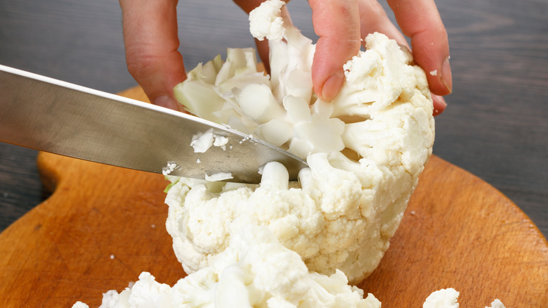 Cutting cauliflower on cutting board