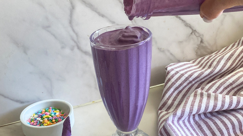 purple milkshake pouring into glass