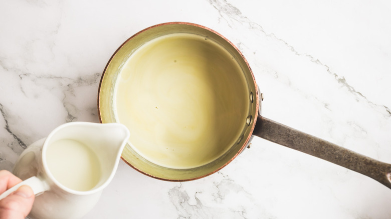 adding milk to saucepan with pistachio milk