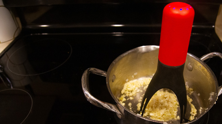 Automatic pan stirrer in pan of garlic