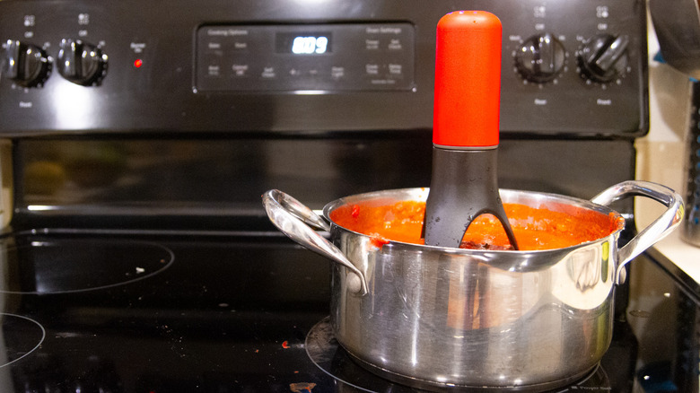 Automatic pan stirrer in tomato sauce