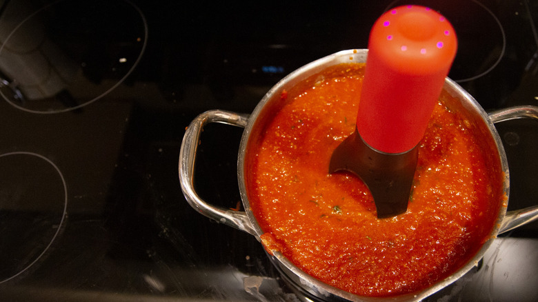 Automatic pan stirrer with tomato sauce