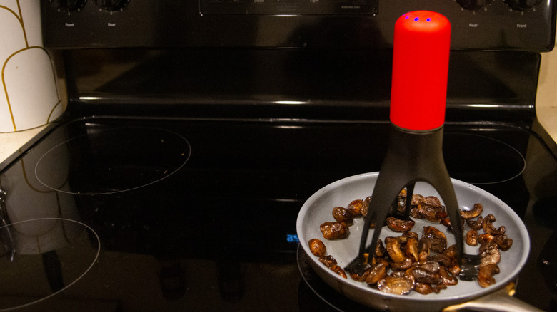 Automatic pan stirrer in pan of mushrooms