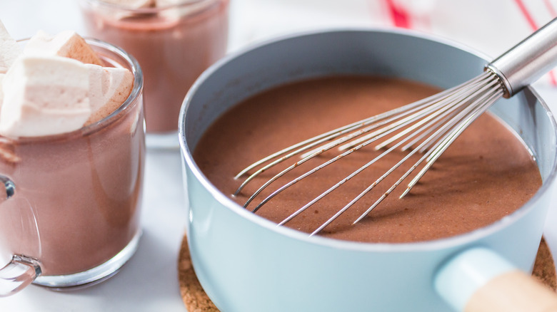 whisk and pot of hot cocoa