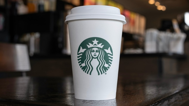 A paper Starbucks cup on a counter