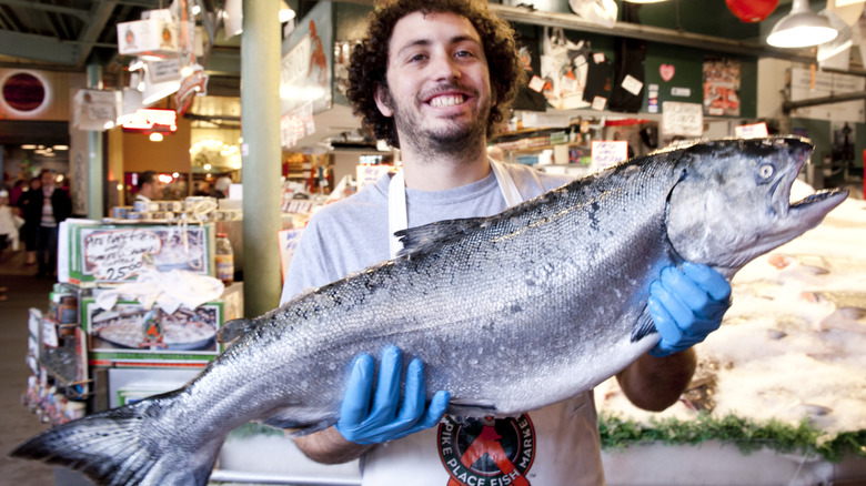 Pike Place fish monger holding salmon