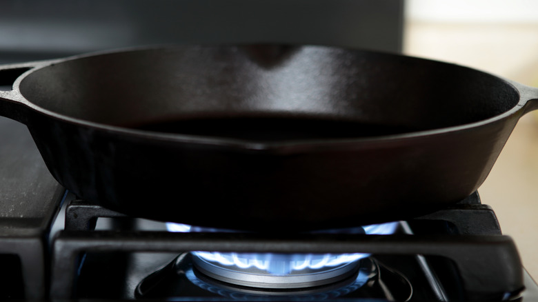 Cast iron pan heating over gas flame