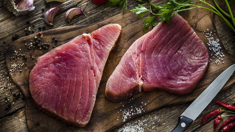 fresh tuna steaks on cutting board