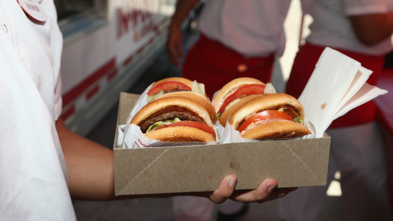 hand holding box of four in n out burgers