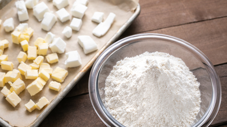 bowl of flour and sheet pan with butter