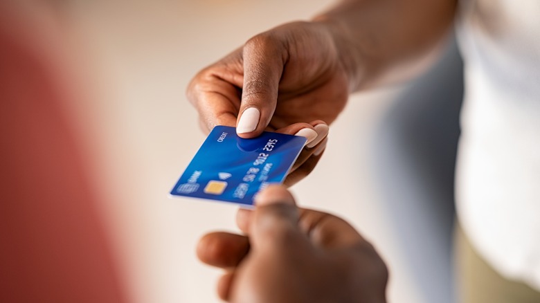 woman handing credit card to man