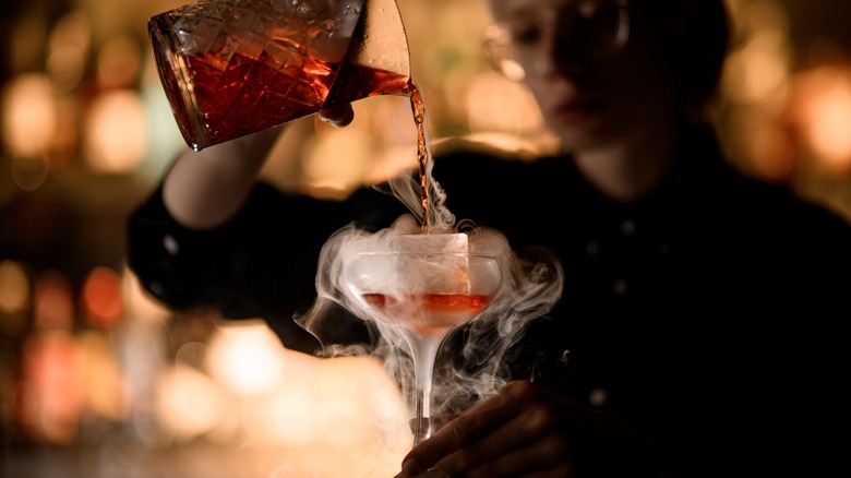 pouring smoky cocktail into glass