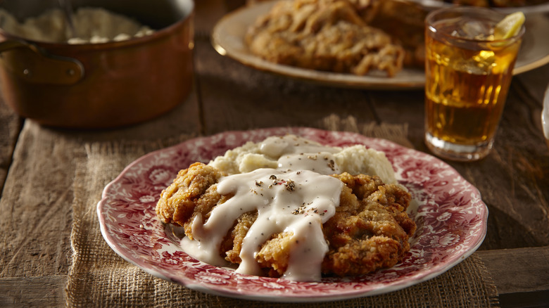 country fried steak with mashed potatoes and gravy on a plate