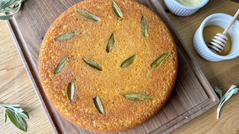 sage leaves on baked cornbread over a wood cutting board