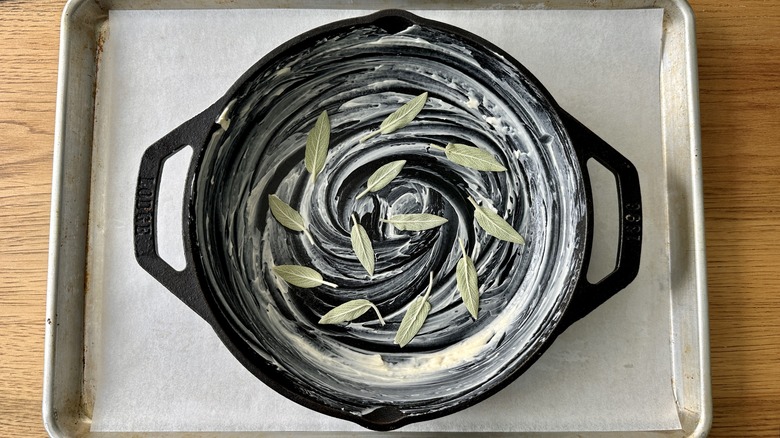 sage leaves spiraled over a buttered cast iron skillet