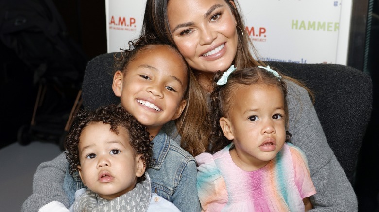 Chrissy Teigen smiling with three of her children