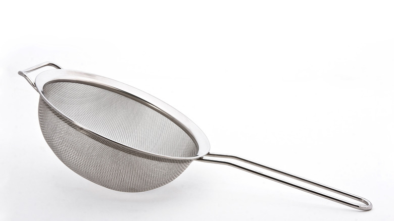Wire fine mesh sieve with a metal handle on a white background