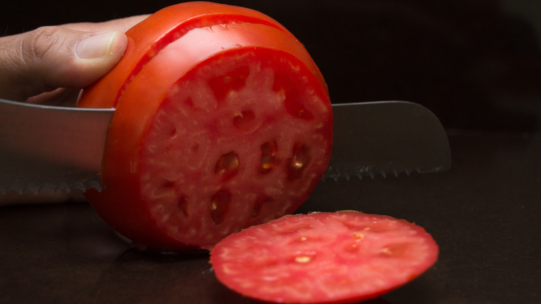 slicing a tomato with serrated knife