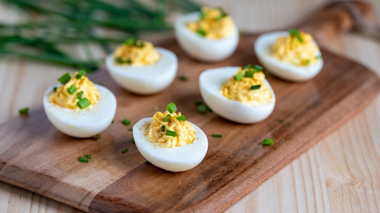 six deviled eggs on cutting board