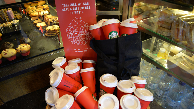 A collection of Starbucks reusable red cups being sold in store