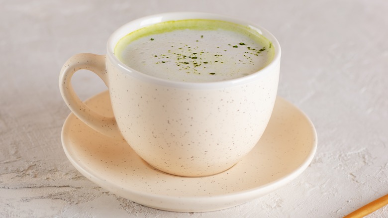 Hot coconut matcha latte in a white mug