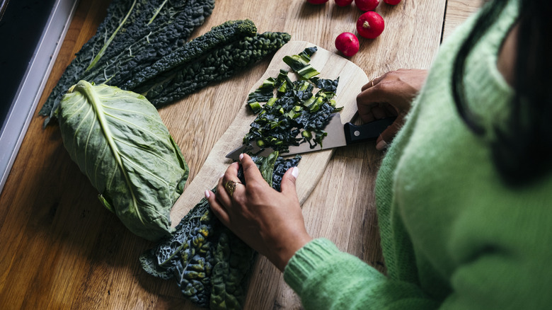 person chopping kale