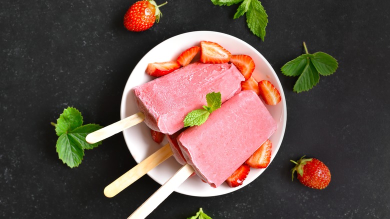 Strawberry popsicles on white plate