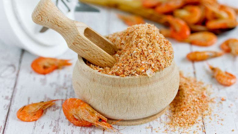 Shrimp powder in a bowl next to shrimps