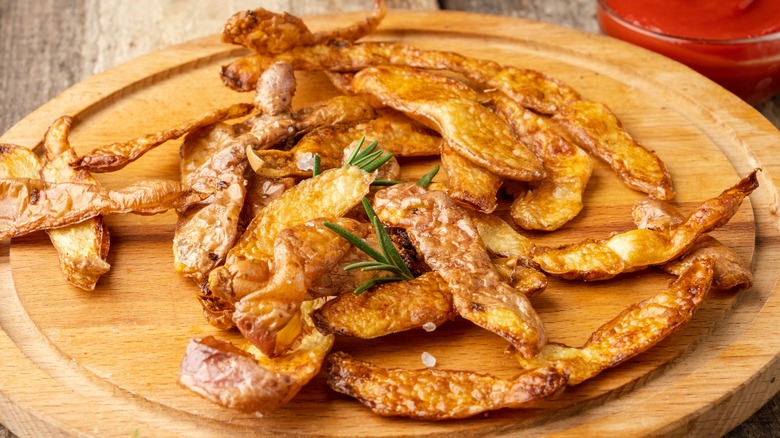 fried potato peels on a wooden board