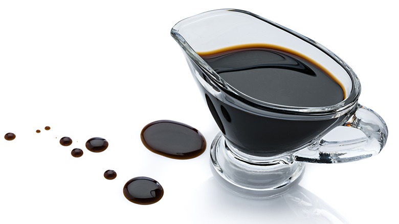 A pitcher of dark balsamic reduction on a white background