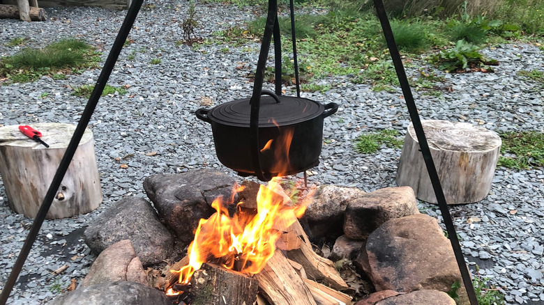 Dutch oven suspended over campfire