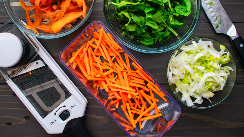 Mandoline and bowls of sliced vegetables