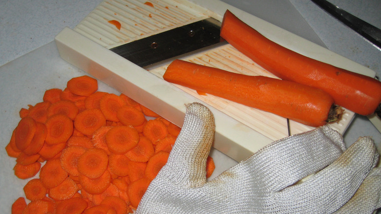 mandoline, sliced carrots, and safety glove