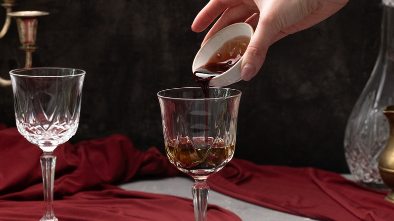 pouring cherry syrup into glass